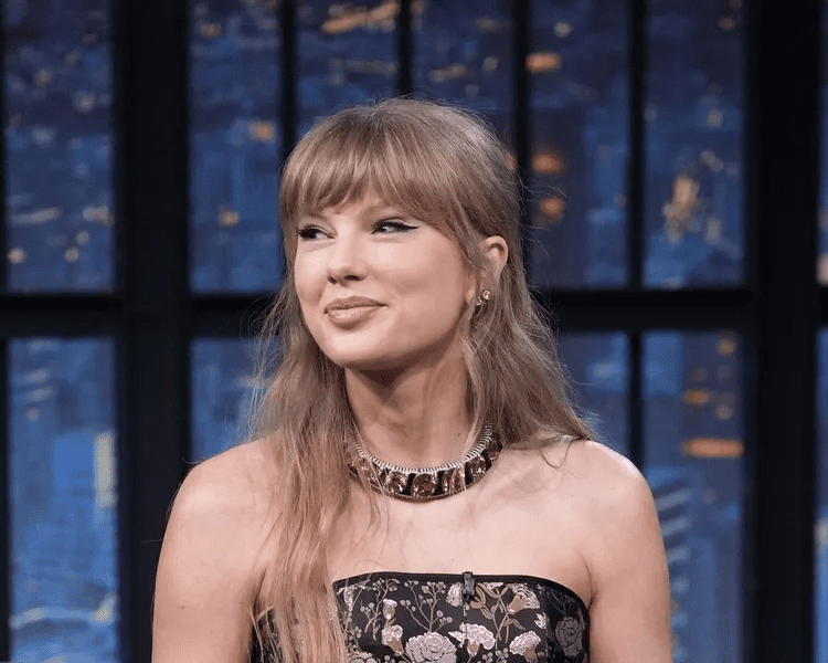 Taylor Swift micro miniskirt red tights look, Taylor Swift divisive winter fashion trend, Taylor Swift The End of an Era screening, Taylor Swift Disney+ docuseries release December 12, Taylor Swift Eras Tour behind the scenes, Taylor Swift Vancouver final show concert film, Taylor Swift bold Y2K tights fashion comeback, Taylor Swift surprise appearance December 2025, Taylor Swift Eras Tour $2 billion gross, Taylor Swift band dancers screening event